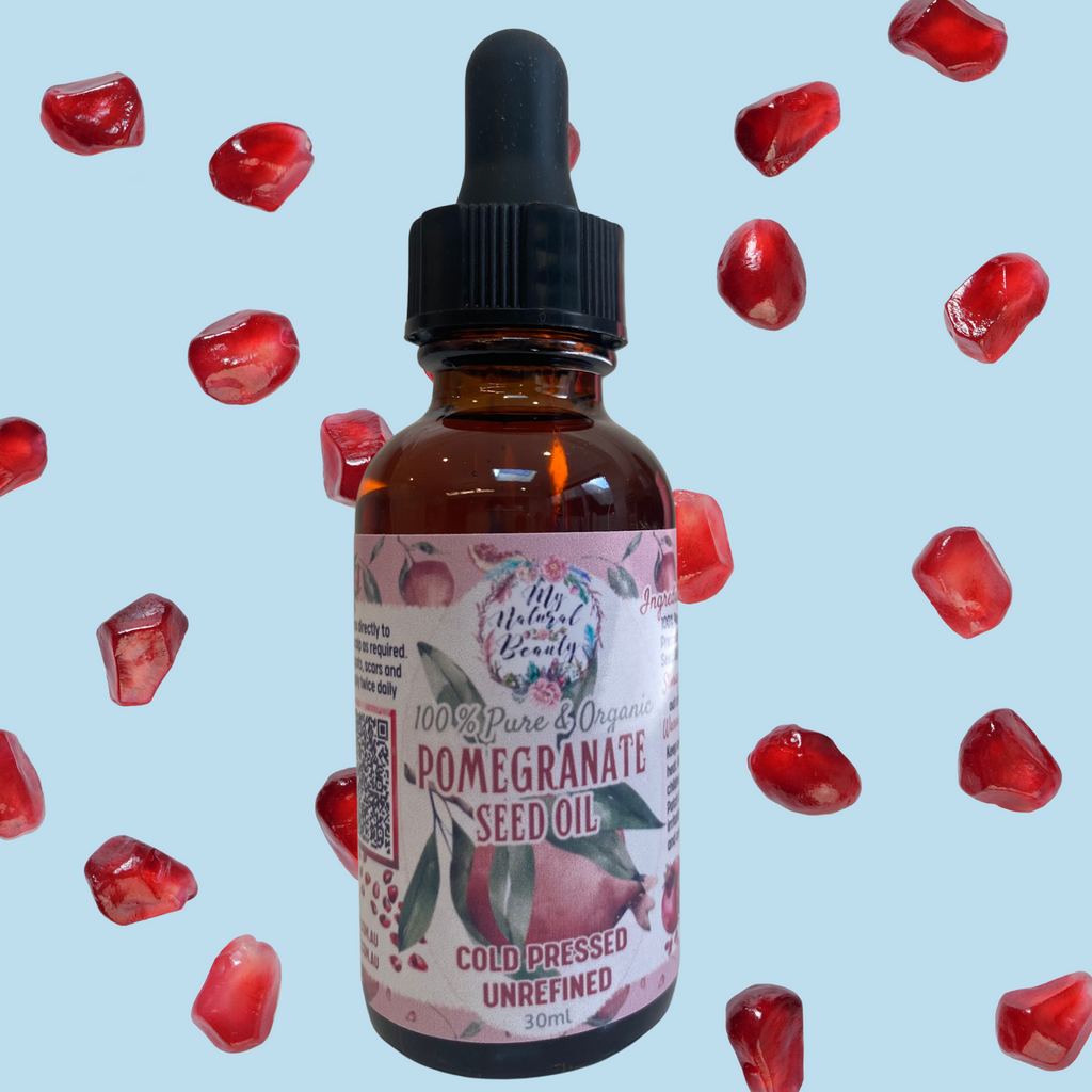 Bottle of pomegranate seed oil with a dropper on a light blue background with floating pomegranate seeds.